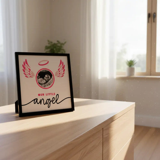 Framed artwork with angel wings, halo, and ultrasound of a baby, featuring the text 'Our Little Angel'.