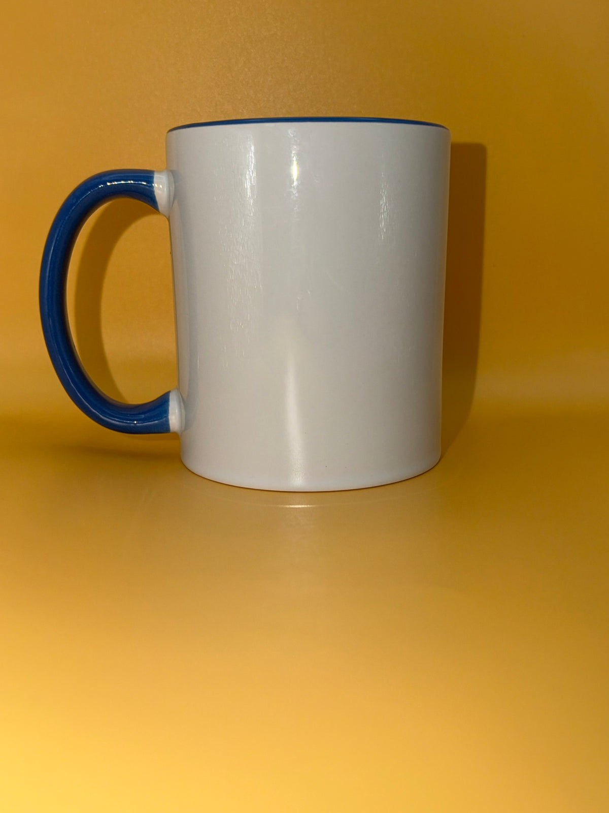 White mug with a light blue handle, shown from the side