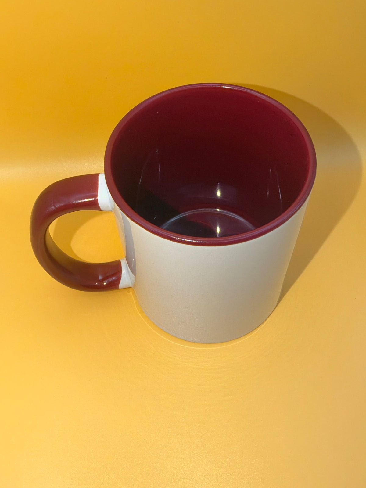 Maroon mug showing its coloured interior and handle
