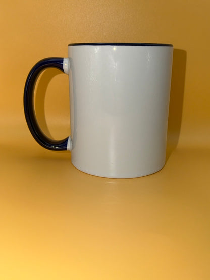 White mug with a dark blue handle, shown from the side