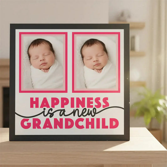 Decorative poster with two pink frames and text 'Happiness is a new grandchild' on a white background.