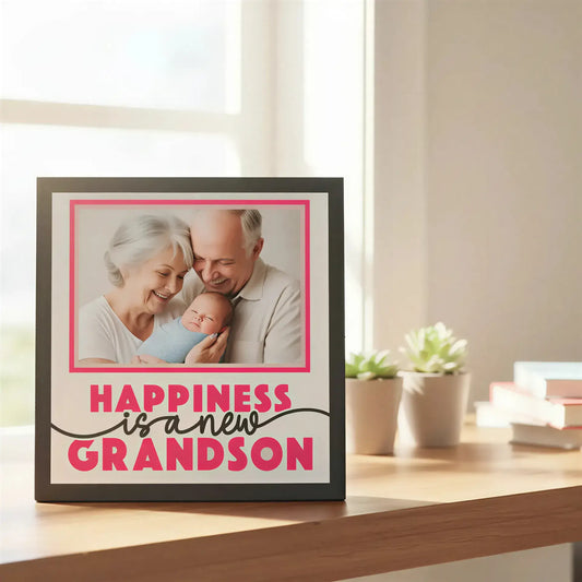 Framed text graphic with 'Happiness is a new grandson' on a white background