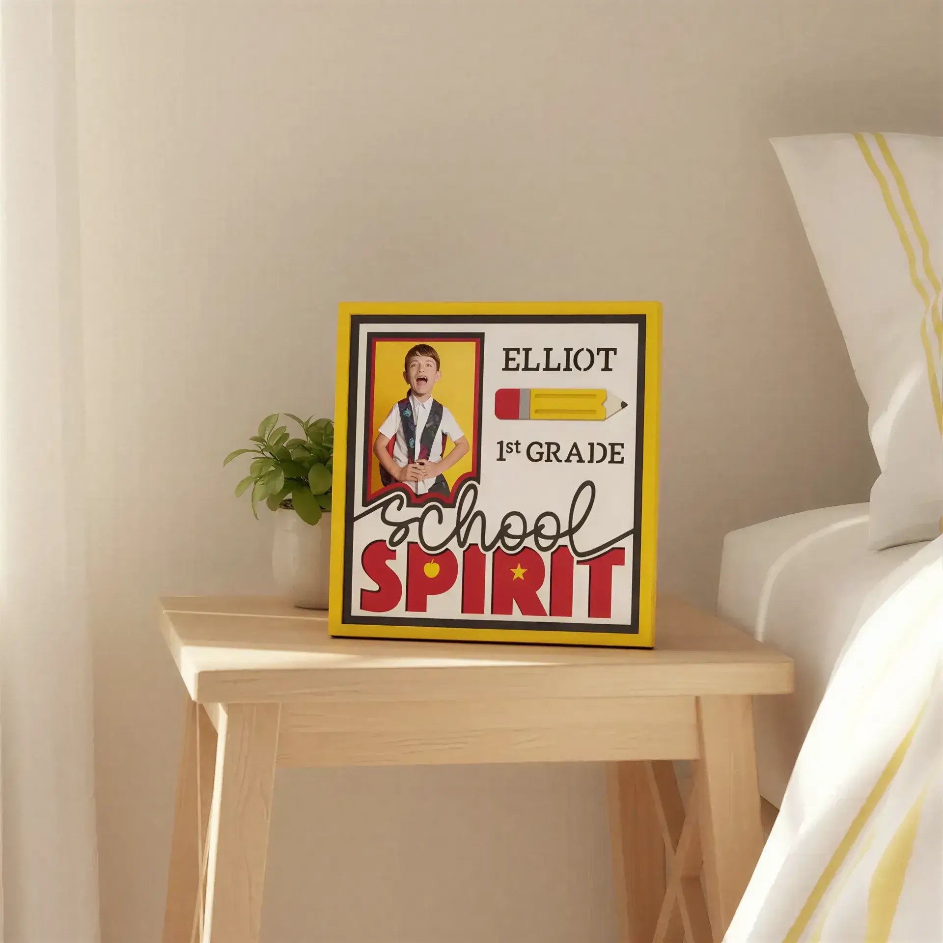 School-themed graphic with a child, pencil, and text 'Elliot 1st Grade School Spirit' on a yellow background.