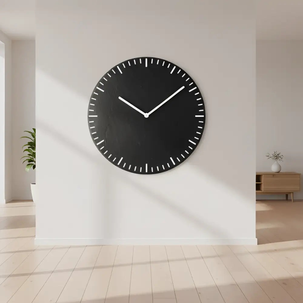 Round black slate clock with white concentric circles on a metal surface