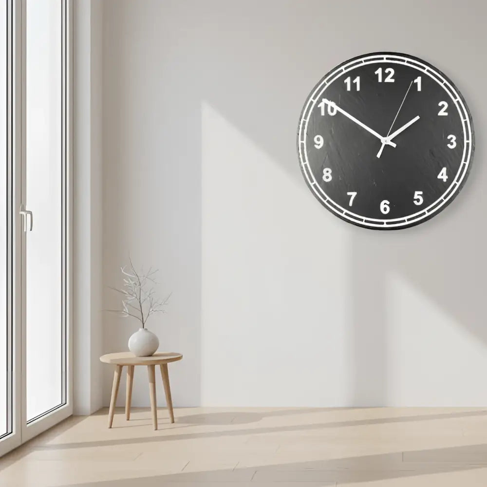 Circular slate clock face with numbers on a metallic background