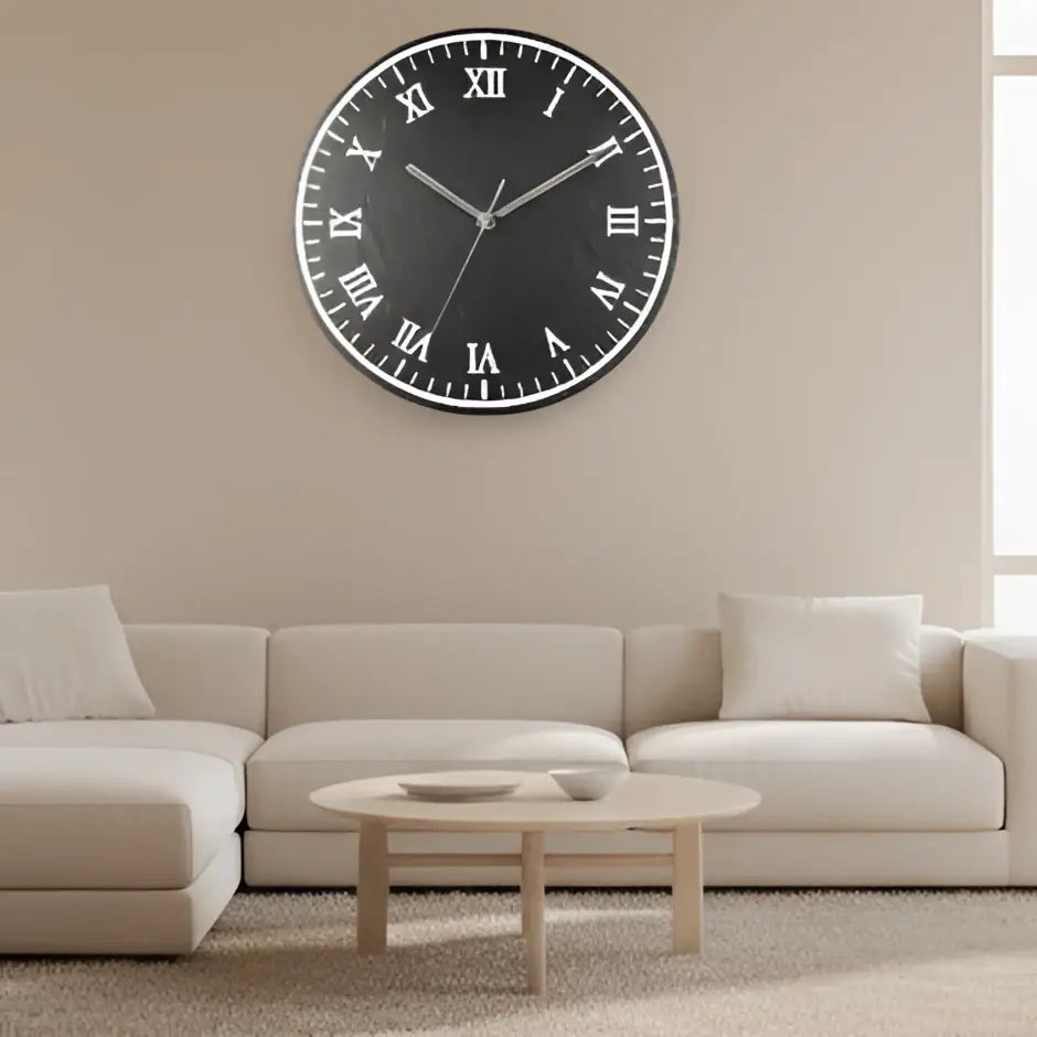 Round slate clock face with Roman numerals on a black background
