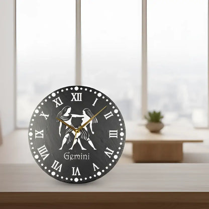 Decorative clock with Gemini zodiac sign and Roman numerals on a black slate background