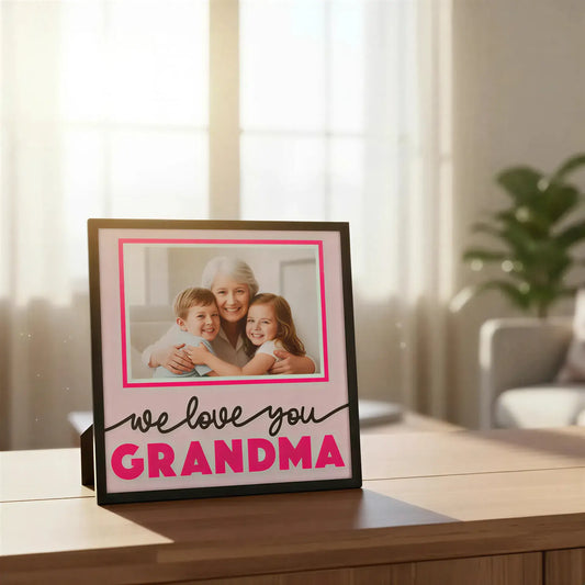 Framed picture with 'we love you GRANDMA' text on a pink background