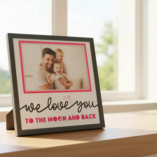 Framed quote 'we love you to the moon and back' with pink hearts on a white background
