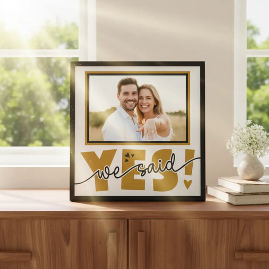 Decorative sign with 'YES! we said' text in gold on a white background