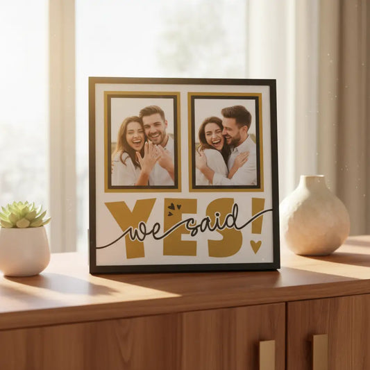 Decorative wall art with 'we said yes!' text and two empty frames on a white background.